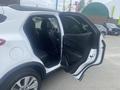A 2018 Buick Encore with an open passenger door revealing black leather seats and interior features