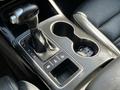 A close-up view of the gear shift and center console of a 2017 Kia Sorento featuring a black leather interior and cup holders