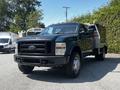 A 2008 Ford F-550 with a black exterior and utility body parked with visible lights on the roof and a front grille featuring the Ford logo