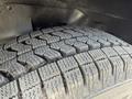 A close-up of a tire with a deep tread pattern mounted on a 2020 Chevrolet Express