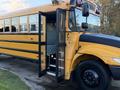 A yellow 2014 International 4300 school bus with an open door and steps leading inside