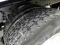Close-up of a tire from a 2011 International 4400 featuring deep treads with visible wear and dirt accumulation on the surface