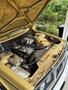 A 1978 Volvo 244 with its hood raised showing the engine compartment and components including the air intake and various fluids