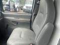 A gray leather driver's seat from a 2004 Ford Econoline van with an interior view of the door handle and window controls