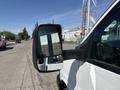 A white 2017 Chevrolet Express van with a side mirror reflecting a nearby vehicle and portion of the street