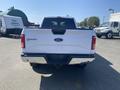 A white 2017 Ford F-150 pickup truck viewed from the rear with a chrome bumper and Ford emblem on the tailgate