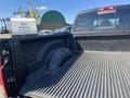 The image shows the bed of a 2011 RAM 1500 pickup truck with a textured black liner and a RAM logo embossed on the front wall