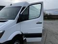 A white 2016 Mercedes-Benz Sprinter van with an open driver's side door showing the interior and side mirror