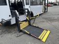 A 2017 Chevrolet Express with a deployed wheelchair ramp featuring yellow handles and safety straps