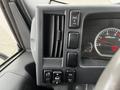 Control panel of a 2022 Isuzu NPR featuring various buttons and a speedometer with a needle measuring RPM