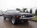 A 1974 Dodge Challenger in black with a sleek design featuring round headlights and distinctive lines on the sides