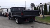 A black 2012 International TerraStar truck with a flatbed and dual rear wheels is parked, showcasing its sturdy construction and utilitarian design