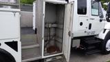 A metal storage compartment on a 2012 International 7400 truck with a few metal chains lying inside