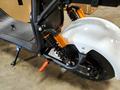 A close-up view of a 2021 Citycoco 2000W electric scooter featuring black and orange shock absorbers and a white rear fender with a visible wheel and brake disc