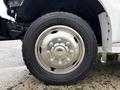 Close-up of a shiny metallic wheel of a 2000 Ford F-450 with black rubber tire showing water droplets on the surface