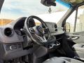 Interior view of a 2019 Mercedes-Benz Sprinter featuring a steering wheel dashboard and control panel with cup holders