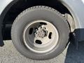 A close-up view of a silver wheel with a five-bolt pattern mounted on a 2018 Chevrolet Express tire