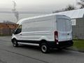 A white 2017 Ford Transit van is parked with a high roof and sliding side door displaying its sleek design and spacious cargo area