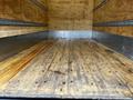 Interior view of a 2021 Mitsubishi FE truck bed featuring a wooden floor and metal lining without any cargo present