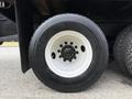 Close-up of a black tire mounted on a white wheel with a silver lug nut pattern labeled with the tire brand Michelin and size 10R22.5 XDE M/S