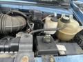 Engine compartment of a 2006 Ford Econoline with visible components like the air intake hose coolant reservoir and various hoses and cables