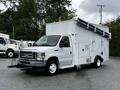 A white 2013 Ford Econoline van with a large mounted structure on the back and several pipes extending from its sides