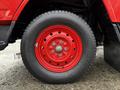 A red wheel from a 2001 Toyota Dyna featuring a circular rim with multiple holes and a textured black tire with visible tread patterns