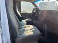 Interior view of a 2016 GMC Savana van showing the driver's seat and passenger seat with gray upholstery and the dashboard in the foreground