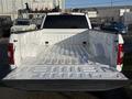 A 2018 Ford F-150 with an open white truck bed showing its interior space and equipment storage design