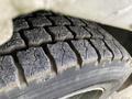 Close-up of a worn tire tread on a 2002 Ford F-550 showcasing deep grooves and dirt accumulation on the surface