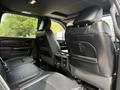 Interior view of the back seats of a 2024 RAM 3500 featuring leather upholstery and a center console with controls and cup holders