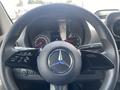 The steering wheel of a 2025 Mercedes-Benz Sprinter featuring the brand's logo and various controls for navigation and vehicle functions