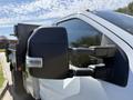 Close-up of the side mirror of a 2019 Ford F-550 showing a black housing and integrated turn signal with a reflection visible in the mirror glass