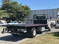 A 2018 International DuraStar truck with a flatbed and a low profile positioned at an angle showing its rear and side features