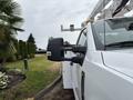 A white 2018 Ford F-550 with a prominent side view mirror and a utility body designed for service work