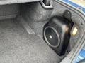 A subwoofer is installed in the trunk of a 2022 Dodge Charger on a carpeted surface