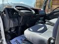 Interior of a 2016 Isuzu NPR with a driver's seat and dashboard visible featuring controls and a steering wheel