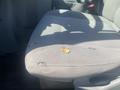 A worn and torn passenger seat in a 2009 Ford Econoline with visible fraying and a small hole in the fabric