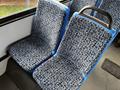 A pair of patterned bus seats with blue backs and a gray and black floral design on the cushions