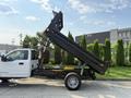 A 2022 Ford F-550 truck with a raised dump bed positioned at an angle