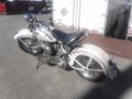 A white 1947 Harley-Davidson WL motorcycle with chrome accents and a classic design parked on a surface