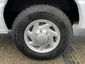 A silver wheel with a Goodyear Wrangler tire mounted on a 2009 Ford Econoline