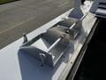 Two metallic brackets are mounted on a white surface designed for securing equipment or tools