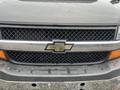 Front view of a 2017 Chevrolet Express featuring a black grille with a silver bowtie emblem and an orange accent below the grille