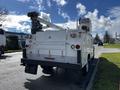 A white 2016 Ford F-550 truck equipped with a service body and a mounted aerial lift on the rear