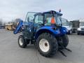 A blue 2016 New Holland T475 tractor with a front loader attachment and large tires positioned securely on a flat surface
