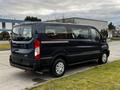 A 2020 Ford Transit van in dark blue with a spacious passenger area and chrome accents parked on a driveway