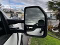 A close-up of the side mirror on a 2020 Ford F-250 SD showing a reflection in the glass