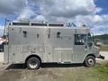 A 2007 Morgan Olson Workhorse W42 delivery truck with a metallic exterior featuring multiple compartments and a ladder mounted on top