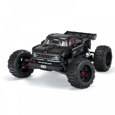 A black Arrma 1/5 Outcast 8S EXB 4X4 roller brushless stunt truck with oversized tires and a sleek design featuring a detailed front grille and aggressive stance